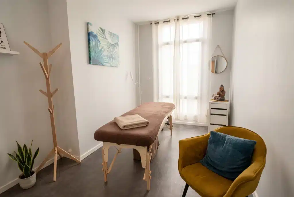 Cabinet de massage avec table de massage inclue, mobilier design et pièce lumineuse