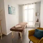Cabinet de massage avec table de massage inclue, mobilier design et pièce lumineuse